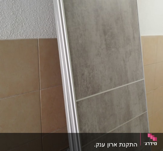 לוח עץ עם מסגרת מתכת על קיר